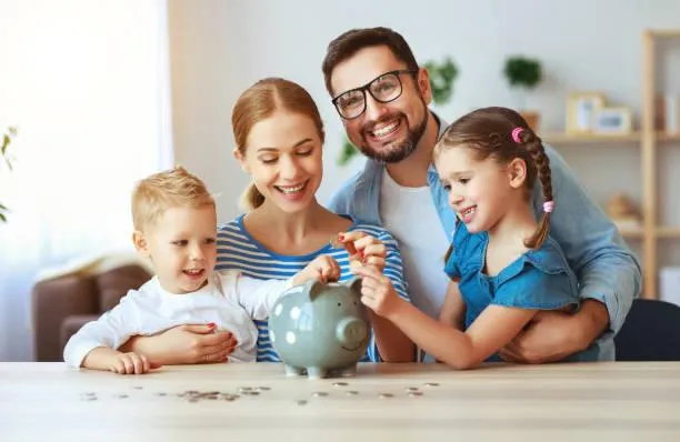 Family saving coins in a piggy bank